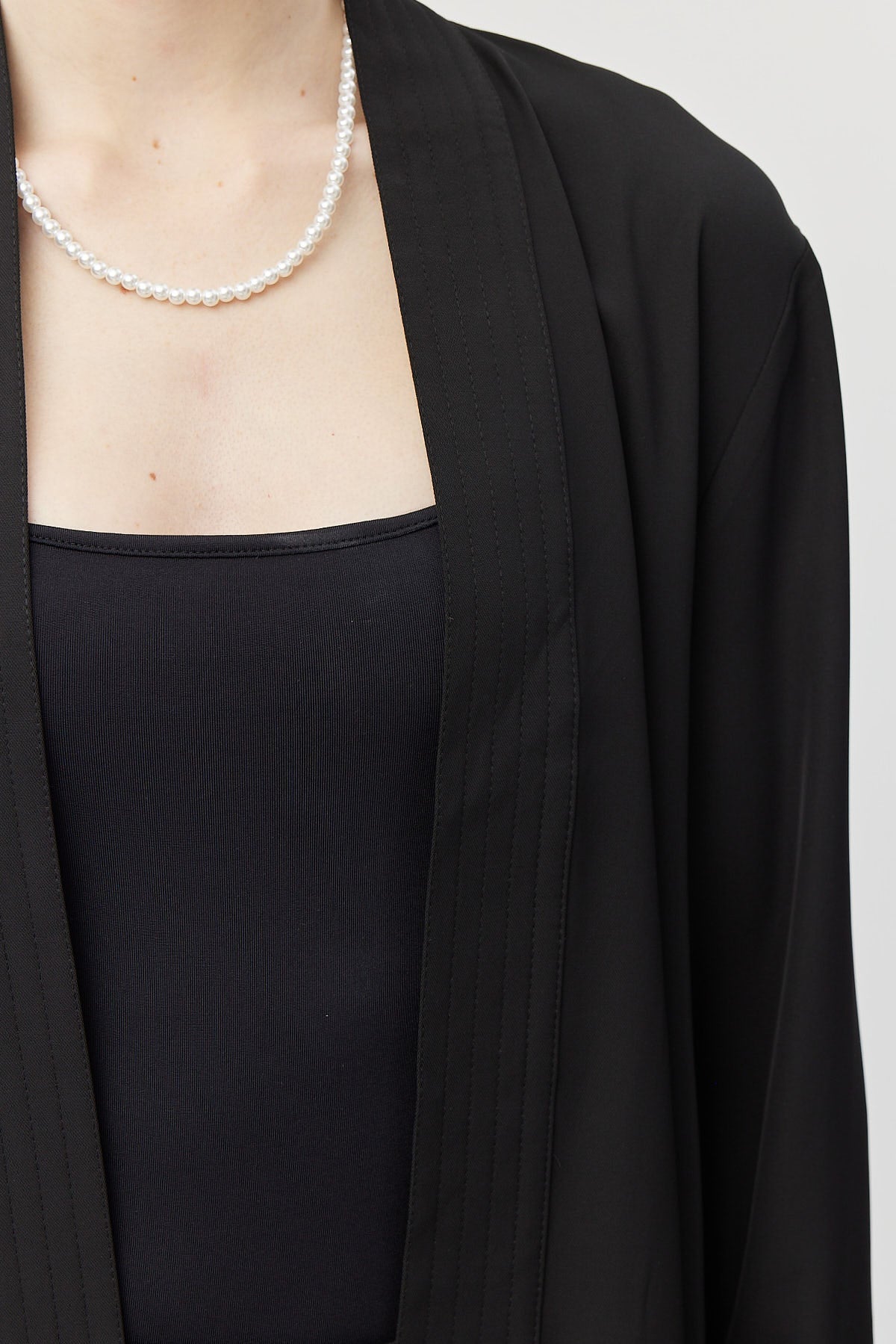 جاكيت نسائي بحزام وقصة غير متماثلة وغير مبطن